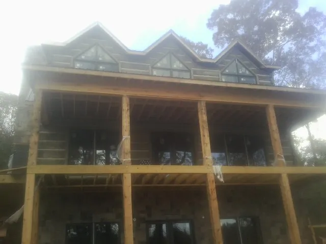 Dormers and porch framing on a large log home under construction in Plymouth